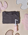 Overzicht van Essentuary postpartum essentials voor in elk vluchtkoffer, met het kraamverband, de Peri Bottle, de bostkompressen, en de bevallingsjurk